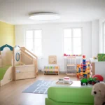 Blick in den Gruppenraum mit Kinderkletterturm und Spielzeug