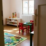 Blick durch eine Tür in einem Gruppenraum mit Kindertische und Spielzeug