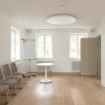 Veranstaltungsraum mit Holzboden, Tisch, Stühlen, Flipboard