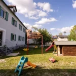 Garten mit kleiner Rutsche und kleinem Spielholzhäuschen