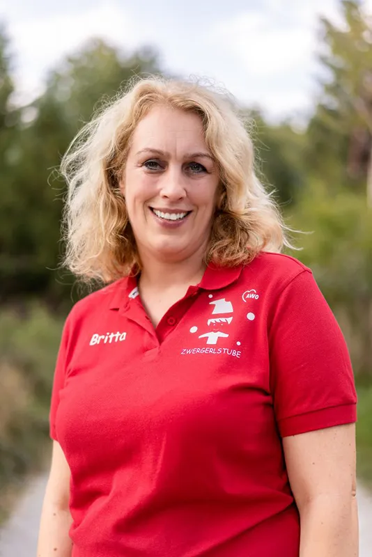 Frau mit rotem Shirt, lange blonde Haare, lächelt