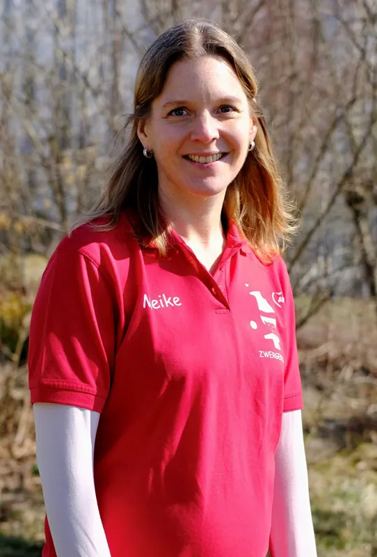 Frau mit rotem Shirt, lange braune Haare, trägt sie offen, lächelt